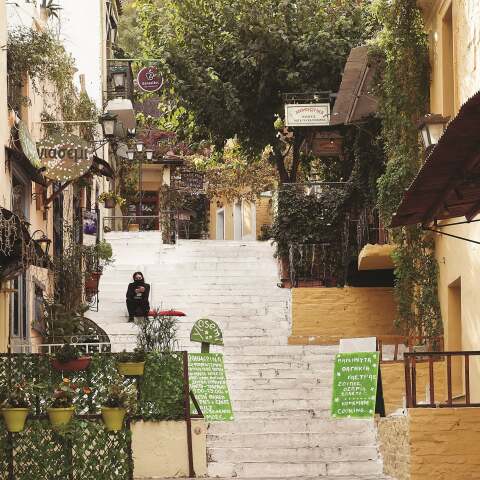 Γυναίκα με μάσκα που κάθεται σε σκαλιά στην περιοχή Αναφιώτικα στην Αθήνα κατά την περίοδο του lockdwon