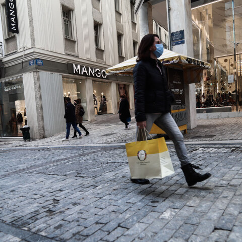 Γυναίκα με μάσκα για τον κορωνοϊό και τσάντα με ψώνια στην Ερμού, δύο ημέρες πριν από τα Χριστούγεννα 2020