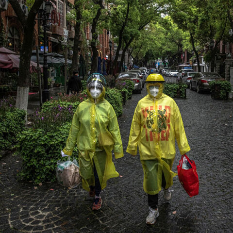 Πολίτες στην Κίνα με προστατευτικές στολές και μάσκες για τον κορωνοϊό