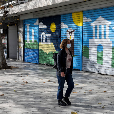 Γυναίκα με μάσκα για τον κορωνοϊό στο κέντρο της Αθήνας - Στο πίσω μέρος κλειστό κατάστημα λόγω lockdown για τον κορωνοϊό