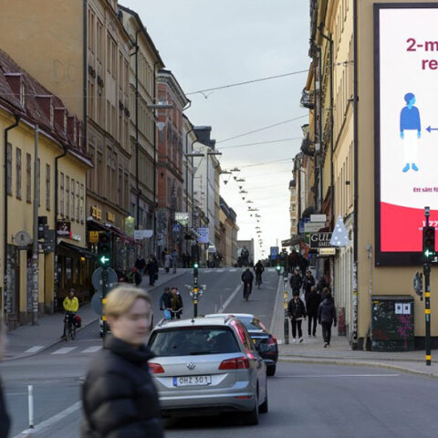 Σουηδία - Κορωνοϊός: Πολίτες χωρίς μάσκες στη Στοκχόλμη, με την ενημερωτική πινακίδα να αναφέρεται στην τήρηση απόστασης τουλάχιστον 2 μέτρων