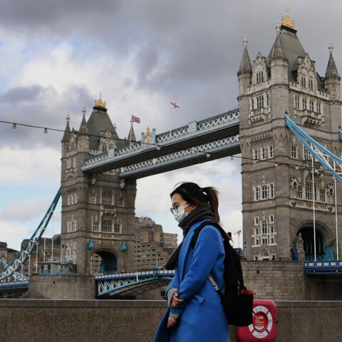 Κορωνοϊός στη Μεγάλη Βρετανία: Κοπέλα φορά μάσκα για Covid-19 με φόντο τη Γέφυρα του Λονδίνου