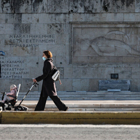 Κορωνοϊός στην Αττική: Μητέρα με το μωρό της, φορώντας μάσκα για Covid-19, περνά μπροστά από το Μνημείο του Αγνώστου Στρατιώτη στο Σύνταγμα