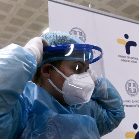 Υγειονομικός του ΕΟΔΥ με μάσκα για τον κορωνοϊό και προστατευτική ασπίδα στο πρόσωπο σε έλεγχο για Covid-19 με rapid test
