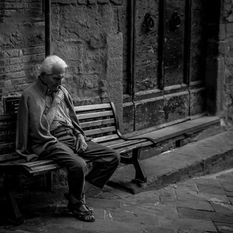 Ηλικιωμένος άνδρας που κάθεται σε παγκάκι