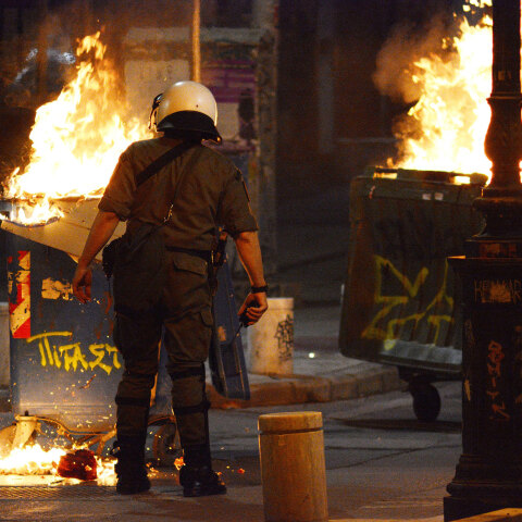Επεισόδια στη Θεσσαλονίκη - Αστυνομικός μπροστά σε κάδους που έχουν παραδοθεί στις φλόγες (ΦΩΤΟ ΑΡΧΕΙΟΥ)
