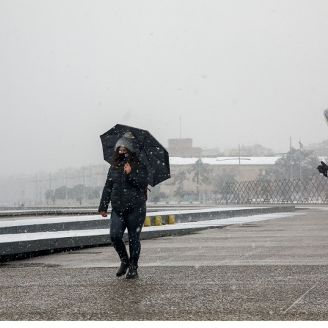 Πολίτες με ζεστά ρούχα και ομπρέλες