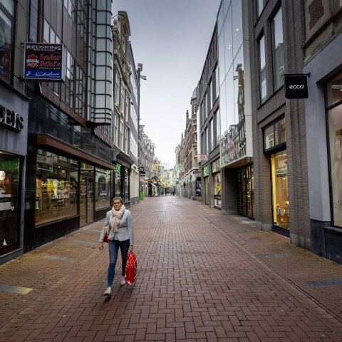 Ολλανδία - Lockdown: Γυναίκα περπατά σε εμπορικό δρόμο στο Άμστερνταμ