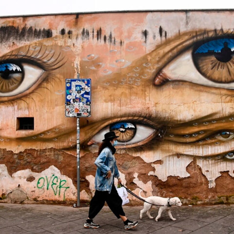 Ιταλία - Κορωνοϊός: Γυναίκα με μάσκα βγάζει βόλτα τον σκύλο στη συνοικία Τραστέβερε στη Ρώμη