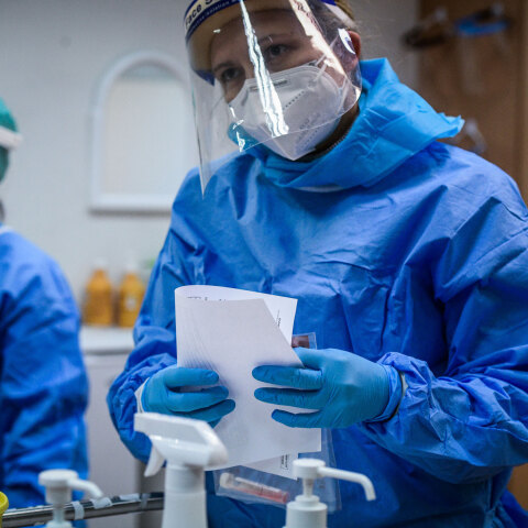 Εμβολιασμοί για τον κορωνοϊό στην Ελλάδα: Υγειονομικοί με μάσκα, ασπίδα, και προστατευτική στολή