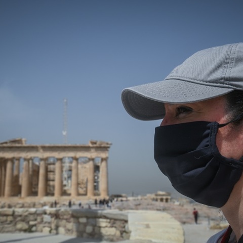 Γυναίκα με μάσκα με φόντο τον Παρθενώνα