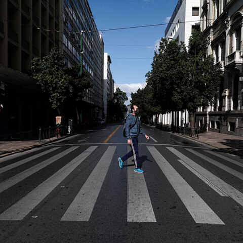 Σκληρότερο lockdown για τον κορωνοϊό: Άνδρας με μάσκα διασχίζει διάβαση πεζών στο κέντρο της Αθήνας