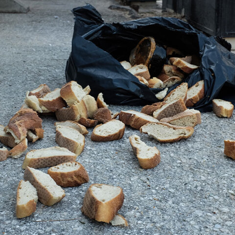 Ανοιγμένη σακούλα με φέτες ψωμί δίπλα από κάδο απορριμμάτων - Στην Ελλάδα φαγητό και τρόφιμα πετιούνται κάθε χρόνο χωρίς να καταναλωθούν