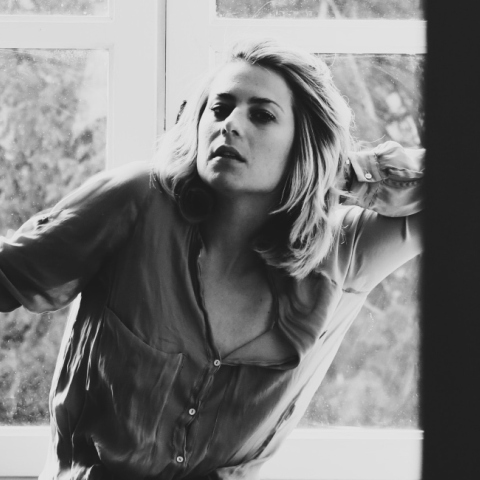 Ασπρόμαυρη γυναίκα που απεικονίζει γυναίκα να στέκεται μπροστά από το παράθυρο