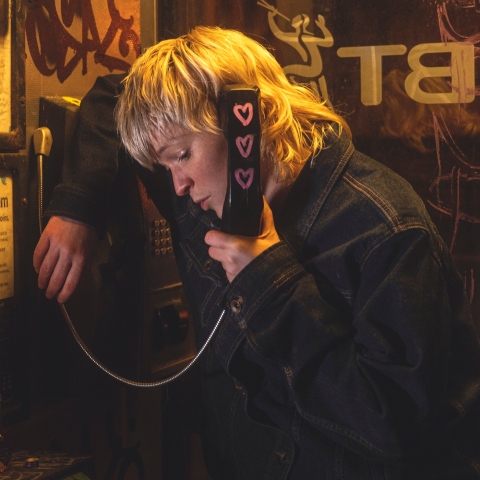 Η τραγουδίστρια Billy Nomates μιλάει σε τηλεφωνικό θάλαμο