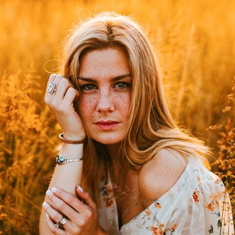 Κοπέλα με άσπρο φλοράλ φόρεμα σε χωράφι