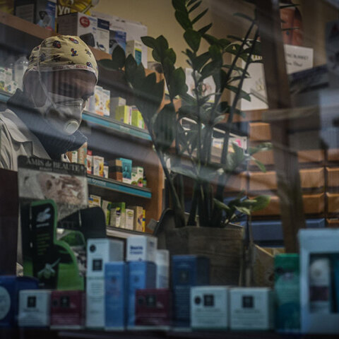 Φαρμακοποιός με μάσκα για τον κορωνοϊό σε φαρμακείο