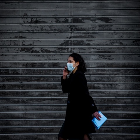 Γυναίκα με μάσκα μπροστά από κλειστό κατάστημα