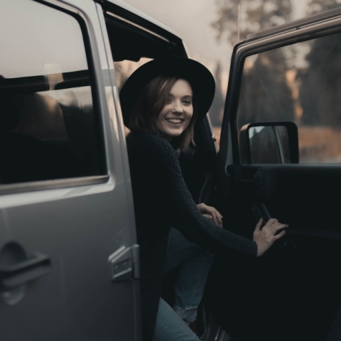 Κοπέλα με μαύρα ρούχα και καπέλο στο αυτοκίνητο