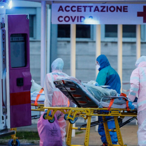 Ιταλία: Υγειονομικοί έξω από νοσοκομείο μεταφέρουν φορείο με ασθενή που έχει κορωνοϊό