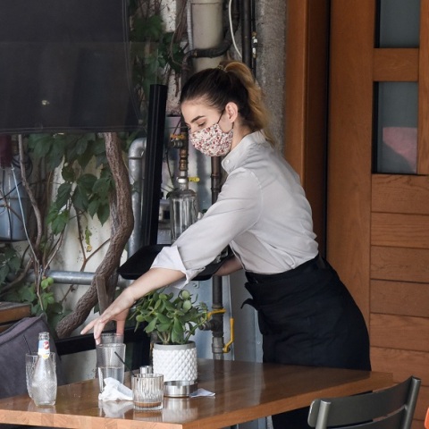 Εργαζόμενη στην εστίαση φορά μάσκα προστασίας