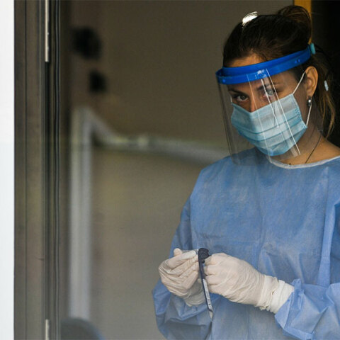 Υγειονομικός του ΕΟΔΥ με μάσκα για τον κορωνοϊό ετοιμάζει rapid test