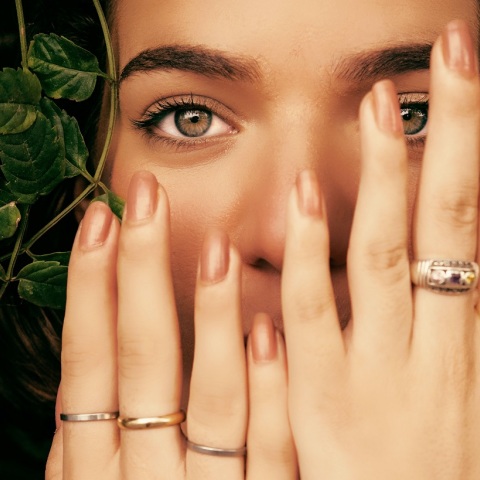 Κοπέλα κρατά τα χέρια της μπροστά στο πρόσωπο δείχνοντας τα νύχια της