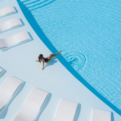 Κοπέλα ξαπλωμένη σε πισίνα