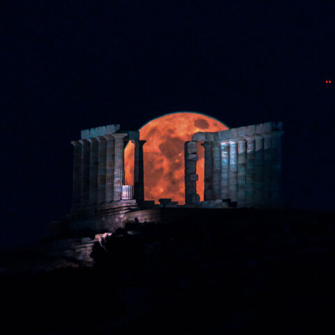Η «ματωμένη» υπερπανσέληνος του Μαΐου ξεπροβάλλει πίσω από τον ναό του Ποσειδώνα στο Σούνιο