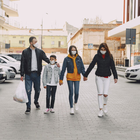 Οικογένεια πιασμένη από το χέρι περπατάει στο δρόμο