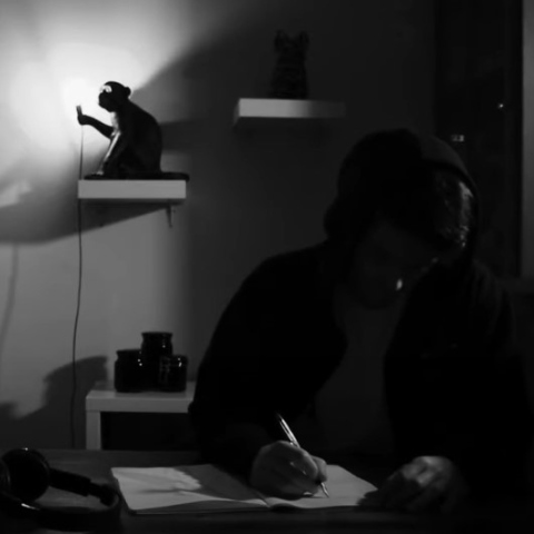 Άνδρας που γράφει σημειώσεις σε τετράδιο - Στιγμιότυπο από βιντεοκλίπ των Qimera