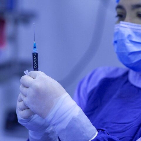 Γιατρός με μάσκα κρατάει στα χέρια της εμβόλιο κατά του Covid-19©Pixabay