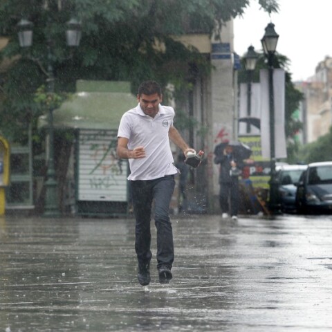 Άντρας τρέχει να αποφύγει τη βριχή στιο κέντρο της Αθήνας©ΑΠΕ-ΑΛΕΞΑΝΔΡΟΣ ΒΛΑΧΟΣ