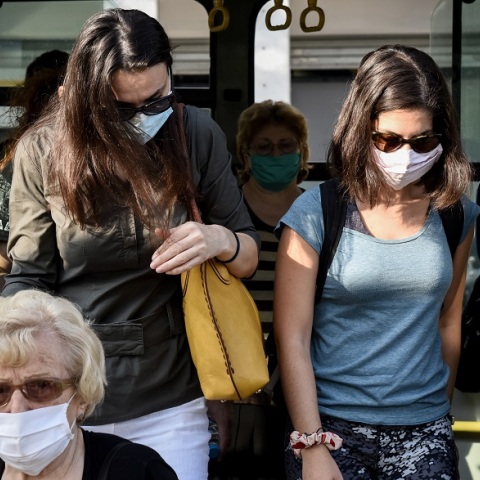 Πολίτες με μάσκα βγαίνουν από λεωφορείο