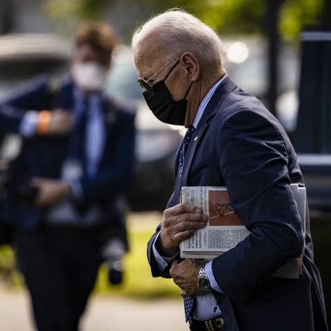 Ο πρόεδρος των ΗΠΑ Τζο Μπάιντεν με μάσκα προστασίας και γυαλιά ηλίου κρατά εφημερίδα