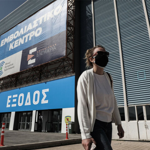 Κοπέλα με μάσκα για τον κορωνοϊό έξω από το mega εμβολιαστικό κέντρο στο Ελληνικό