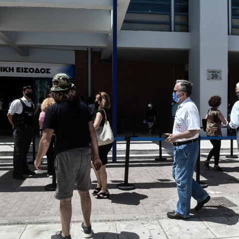 Πολίτες αναμένουν τη σειρά τους για εμβολιαστούν έξω από το εμβολιαστικό κέντρο