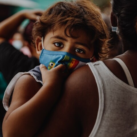 Μαμά κρατάει στην αγκαλιά της μωρό με μάσκα©Unsplash/Taylor Brandon 