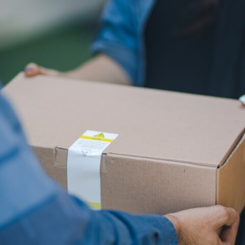 Κούριερ παραδίδει δέμα © Unsplash/RoseBox