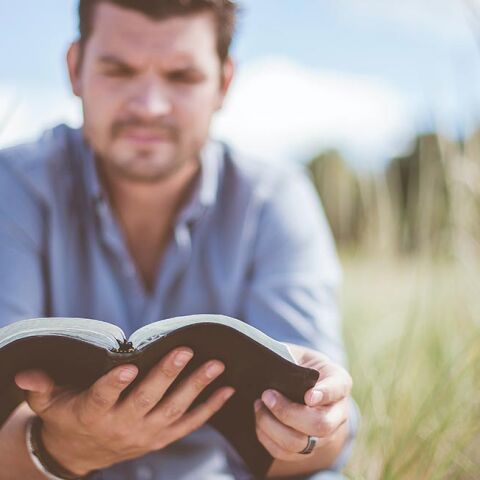 Άντρας που κρατάει βιβλίο και διαβάζει