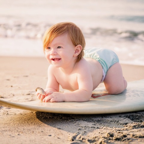 Μωρό σε σανίδα του σερφ στην παραλία