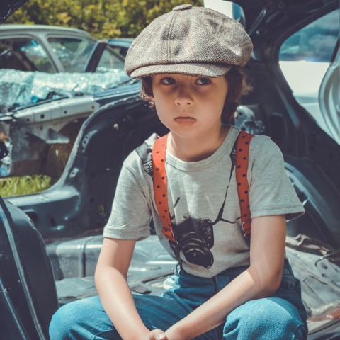 Παιδί με μπερέ που κάθεται σε αυτοκίνητο