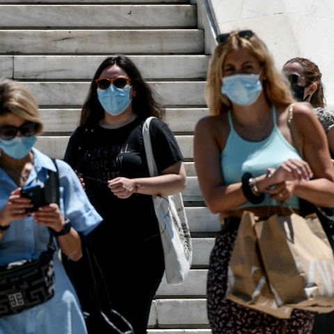Κορωνοϊός: Γυναίκες φορούν τις μάσκες προστασίας και περπατούν στο κέντρο της Αθήνας