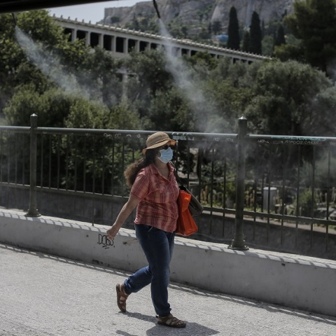 Κύμα καύσωνα - Γυναίκα με γυαλιά ηλίου και καπέλο στην Αθήνα