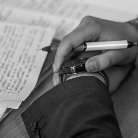 Άντρας με σταυρωμένα χέρια πάνω σε χαρτιά