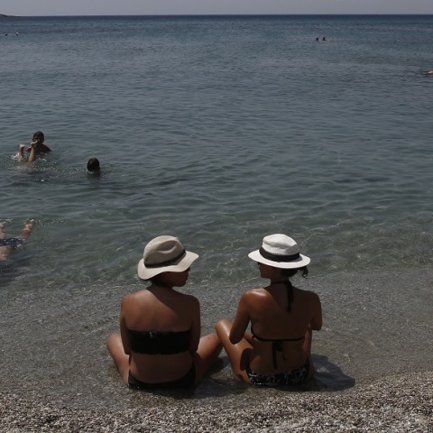 Καύσωνας: Λουόμενοι με καπέλα στην παραλία 