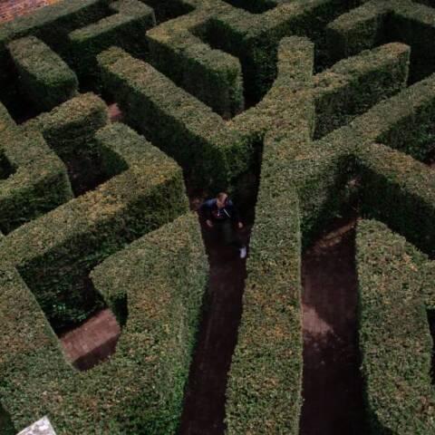 Άντρας που περπατάει μέσα σε λαβύρινθο