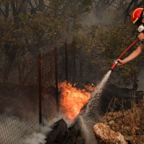 Πυροσβέστης ρίχνει νερό σε φωτιά (ΦΩΤΟ ΑΡΧΕΙΟΥ)