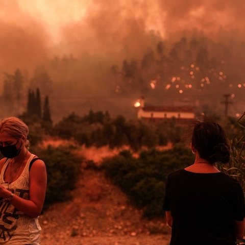 Δύο κάτοικοι παρακολουθούν τις φλόγες να φτάνουν στο χωριό Γούβες. 