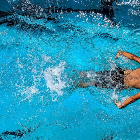 Ένας άντρας κολυμπάει σε μια πισίνα.